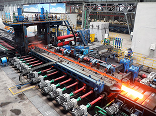 H型钢生产车间内钢材生产紧张有序。