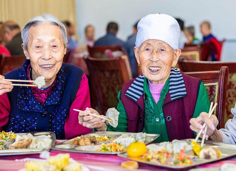 内蒙古呼和浩特市玉泉区敬松老年服务中心的老年人在开心地品尝爱心饺子。